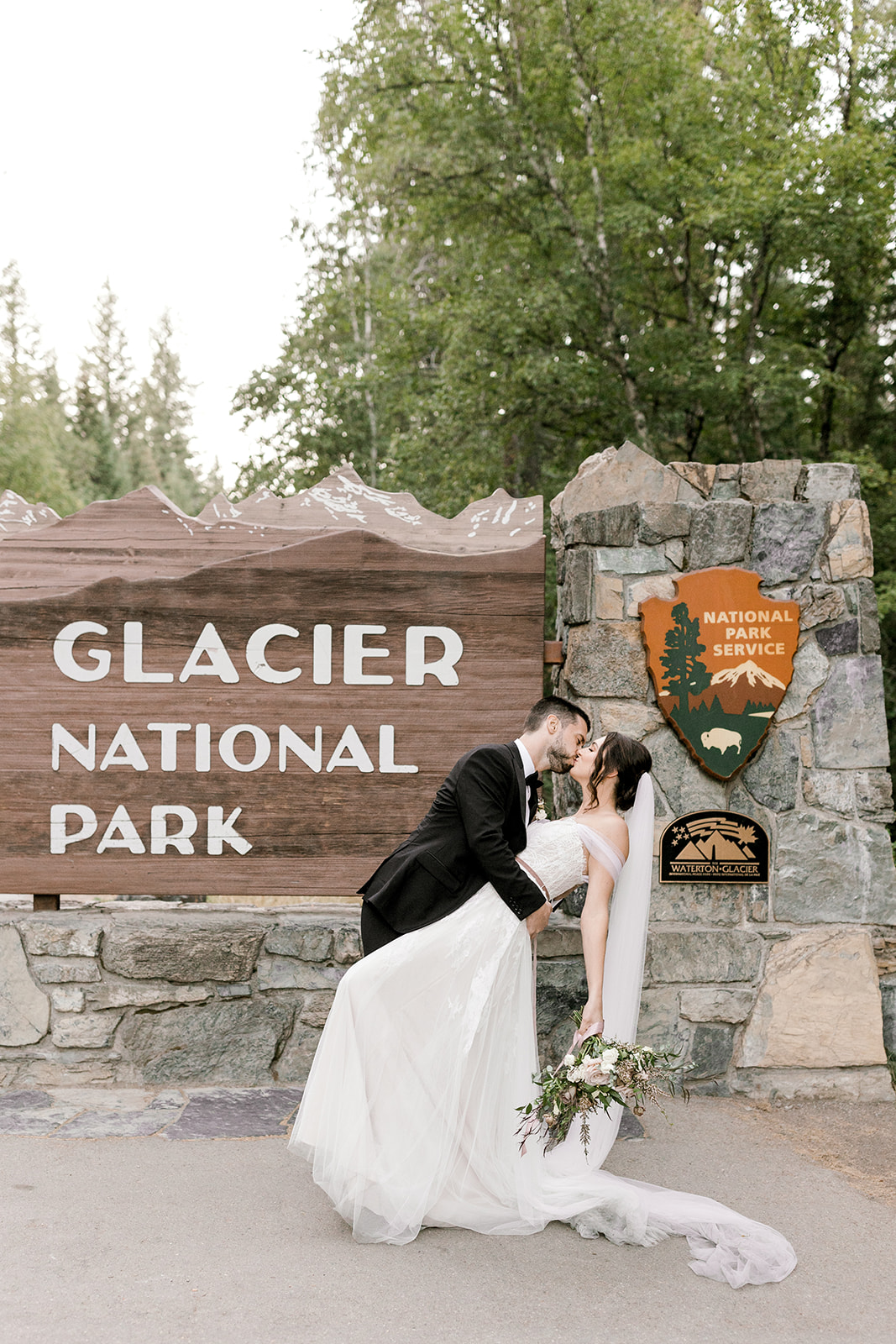 Bride and groom portraits by the Glacier National Park sign